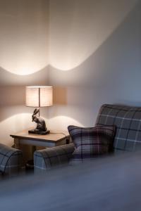 a living room with two chairs and a table with a lamp at Bachilton Farm Holidays in Perth