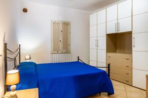 a bedroom with a blue bed and white cabinets at Terra in Casa SantʼEugenia