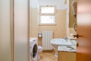a bathroom with a washing machine and a sink at Terra in Casa SantʼEugenia