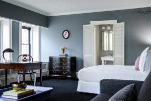 a bedroom with blue walls and a bed and a desk at Hotel Sorrento in Seattle