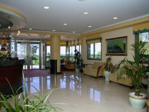 un hall avec des canapés et des plantes dans un bâtiment dans l'établissement Hotel Piñeiro 2 Estrellas Superior, à A Lanzada