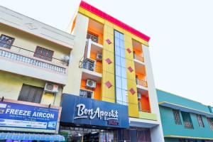 um edifício colorido com uma placa em frente em Sri Abirami Inn em Pondicherry
