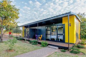 a small house with a yellow and blue facade at SleepOver Orpen Gate in Acornhoek