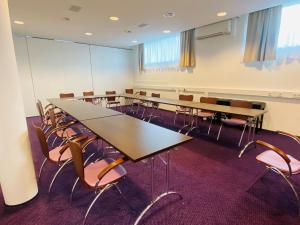 ein Konferenzraum mit Tischen und Stühlen in der Unterkunft Stadthotel Waidhofen an der Thaya in Waidhofen an der Thaya
