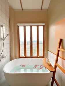 a bath tub in a bathroom with a window at Monko Villa in Pai