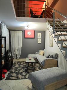 uma sala de estar com um sofá e uma escada em Olivia's Loft House One em Ioannina