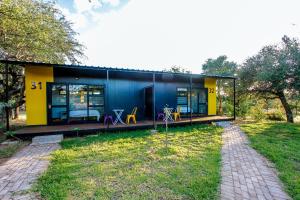 a black and yellow house in a field at SleepOver Orpen Gate in Acornhoek