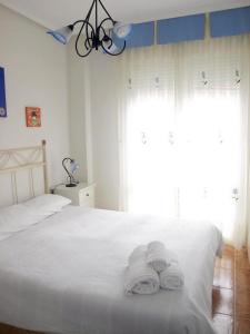 una camera da letto con un letto bianco e asciugamani di Apartamento Alameda Ezcaray, piscina y ascensor a Ezcaray
