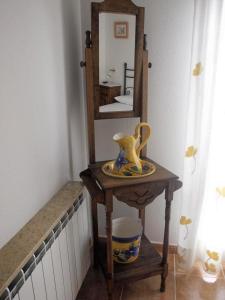 un tavolo con uno specchio e un vaso sopra di Apartamento Alameda Ezcaray, piscina y ascensor a Ezcaray
