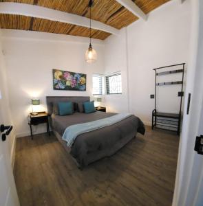 ein Schlafzimmer mit einem großen Bett und Holzböden in der Unterkunft Stone Cottage Riebeek Valley in Riebeek-Wes + 10 Fotos
