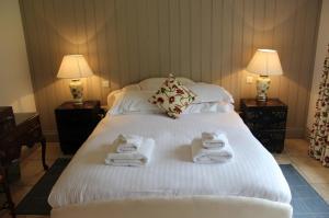 a hotel room with a bed with towels on it at Thornton Manor - Holiday Cottages and Apartments in Heswall