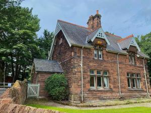 an old brick house with a chimney on top at Thornton Manor - Holiday Cottages and Apartments in Heswall