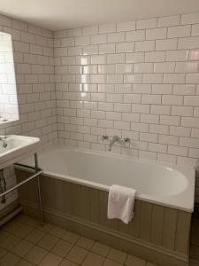 a bathroom with a bath tub and a sink at Thornton Manor - Holiday Cottages and Apartments in Heswall