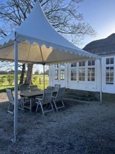 a white tent with chairs and a table in front of a building at Thornton Manor - Holiday Cottages and Apartments in Heswall