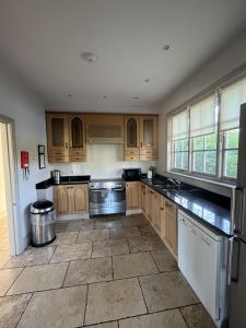 a large kitchen with wooden cabinets and appliances at Thornton Manor - Holiday Cottages and Apartments in Heswall
