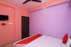 a bedroom with pink and purple walls and a bed at OYO Silver Inn Near Acropolis Mall in Jādabpur