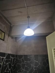 una luce appesa al soffitto in una stanza di Starry Night hostel a Ban Mae Chong