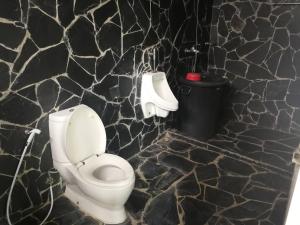 a bathroom with a toilet and a trash can at Starry Night hostel in Ban Mae Chong