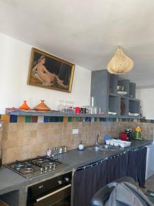 a kitchen with a sink and a stove top oven at Kasbah’s road Art house in Tangier