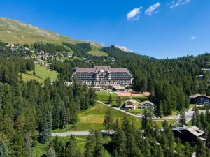 a large building in the middle of a forest at Suvretta House in St. Moritz