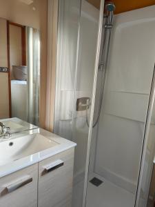 łazienka z prysznicem i umywalką w obiekcie Camping Onlycamp Les Deux Rives w mieście Lannion