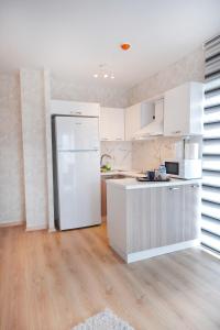 a kitchen with white cabinets and a white refrigerator at King Suite AE8 in Esenyurt