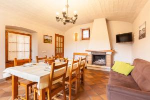 a dining room with a table and a fireplace at El Mas de Tous in San Martín de Tous