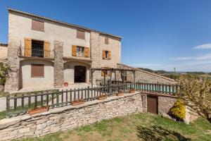 an external view of a stone house with a balcony at El Mas de Tous in San Martín de Tous