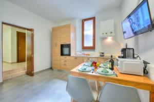 - une cuisine avec une table en bois, des chaises et un four micro-ondes dans l'établissement Mendrisio Corte - Happy Rentals, à Mendrisio