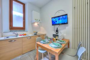 - une cuisine avec une table en bois, des chaises et un évier dans l'établissement Mendrisio Corte - Happy Rentals, à Mendrisio