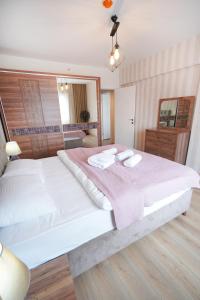 a bedroom with a large bed with two towels on it at King Suite AE8 in Esenyurt