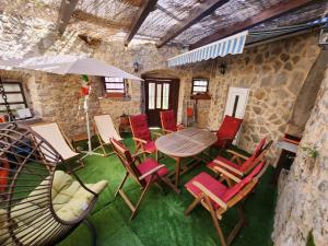 a room with a table and chairs and an umbrella at Lovely holiday home in Cres