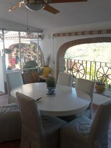 een eetkamer met een witte tafel en stoelen bij Casa Ana Maria in Guaro
