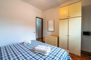 a bedroom with a bed with a blue and white checkered blanket at Fortezza Villa Azzurra in Agnone Bagni