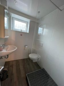 ein Bad mit einem Waschbecken, einem WC und einem Fenster in der Unterkunft Schöne zentrale Zimmer in Wilhelmshaven in Wilhelmshaven