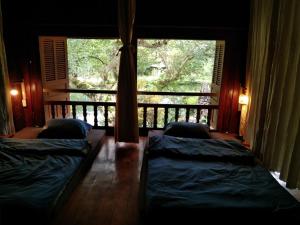 um quarto com 2 camas e uma varanda com uma janela em Mận Homestay - Lục Yên Homestay and Tour 