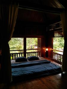 uma cama grande num quarto com uma janela em Mận Homestay - Lục Yên Homestay and Tour 