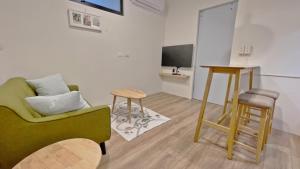 a living room with a green couch and a table at See U Tainan Apartment in Yongkang