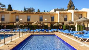 um resort com uma piscina com cadeiras e guarda-sóis em Amazing Seaviw apartment BBQ Ramada res Mijas em Mijas