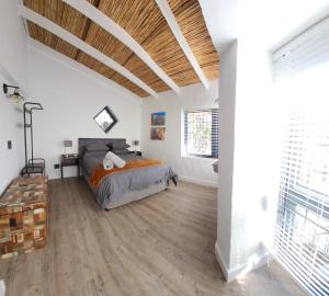 ein Schlafzimmer mit einem Bett und einem Holzboden in der Unterkunft Stone Cottage Riebeek Valley in Riebeek-Wes