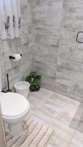 a bathroom with a toilet and a tiled wall at Country Cabin in Midrand