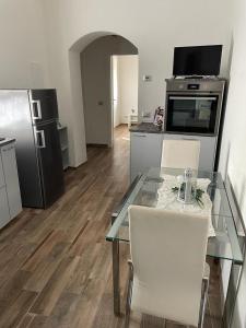 - une cuisine avec une table en verre avec deux chaises et un réfrigérateur dans l'établissement Al vecchio Mulino, à Lastra a Signa
