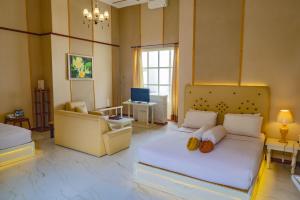 a bedroom with a bed and a couch and a chair at Family Hotel Gradia 1 in Batu