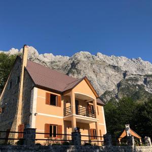a building with a mountain in the background at Cold Springs in Theth
