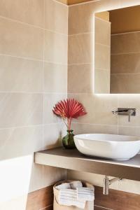 a bathroom with a sink and a vase with a flower at MAR Modena Accommodation in Residence in Formigine