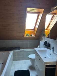 uma casa de banho com uma banheira, um WC e um lavatório. em Auszeit am Federsee em Bad Buchau