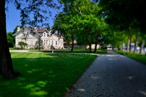una grande casa bianca con alberi e una strada di Château Maucaillou a Moulis-en-Médoc