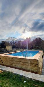 a swimming pool with a wooden fence around it at Le coin tranquille in Morosaglia