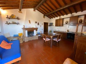 cocina y comedor con mesa y chimenea en La Casina Sonia, en Montaione