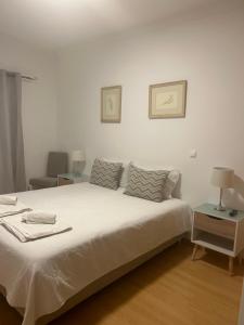 Un dormitorio blanco con una cama grande y una mesa. en Lagos Royal Rooms and Suites, en Lagos